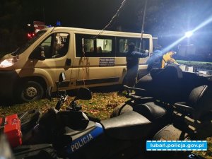 pojazd typu bus obok stoi quad z napisem policja