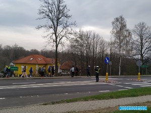 policjantka wstrzymuje ruch na drodze K30 celem przemarszu uczestników rajdu