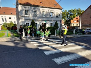 policjanci przeprowadzają dzieci przez przejście dla pieszych