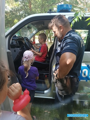 policjant pokazuje radiowóz