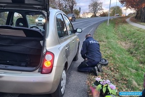 policjant podczas naprawy koła