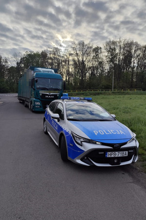 pojazd ciężarowy stojący za pojazdem służbowym policji