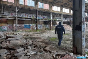 umundurowany policjant kontroluje pustostany pod katem osób bezdomnych