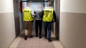 Zdjęcie przedstawia policjantów wydziału kryminalnego prowadzącego mężczyznę