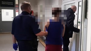 Policjanci prowadzą do sądu podejrzaną o dokonanie uszczerbku na zdrowiu i groźby karalne