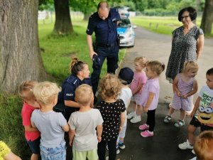 na zdjęciu widać małe dzieci i policjantów rozmawiających z nimi